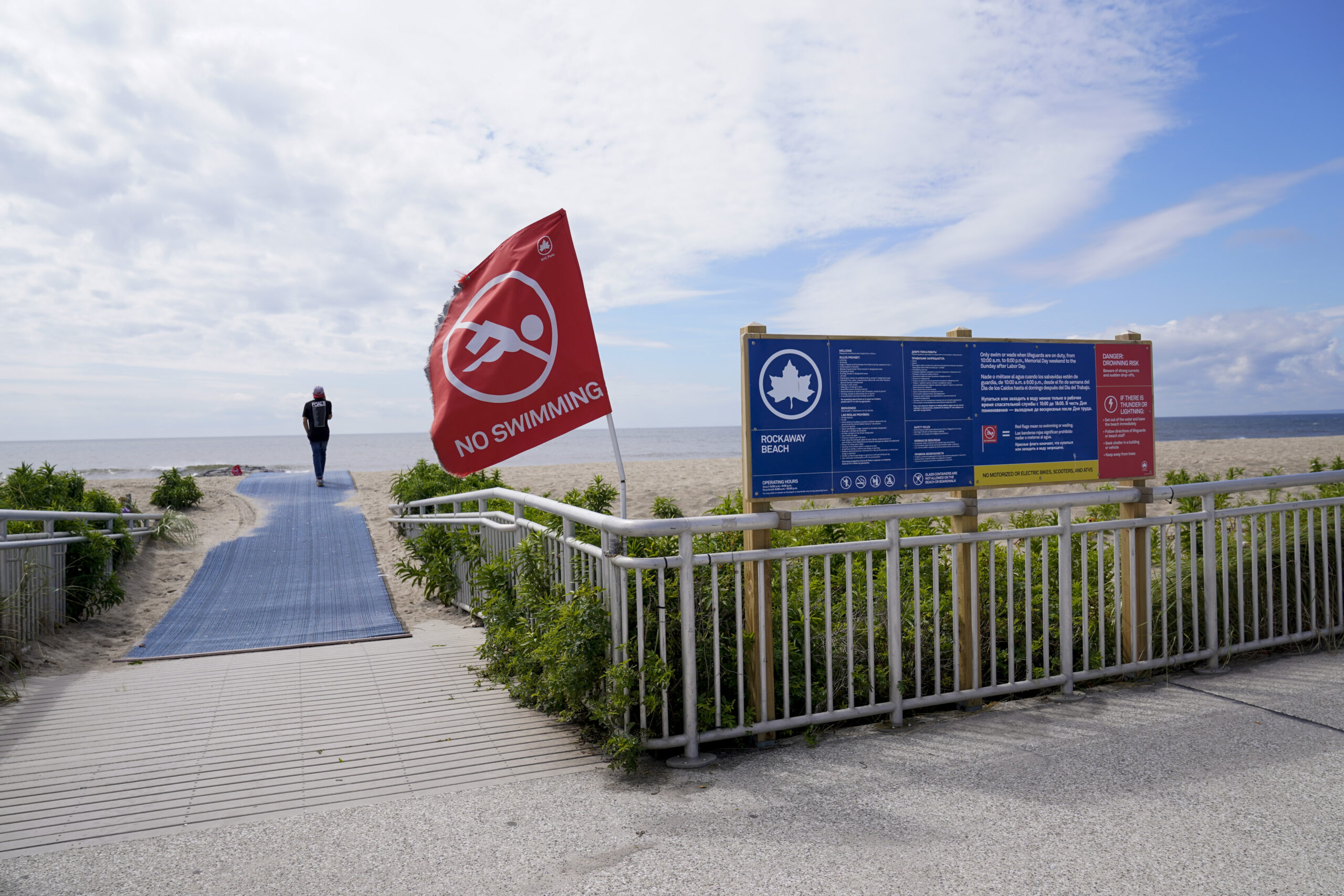 A red flag warning visitors swimming is prohibited is seen at the entrance to Rockaway beach, Tuesd...