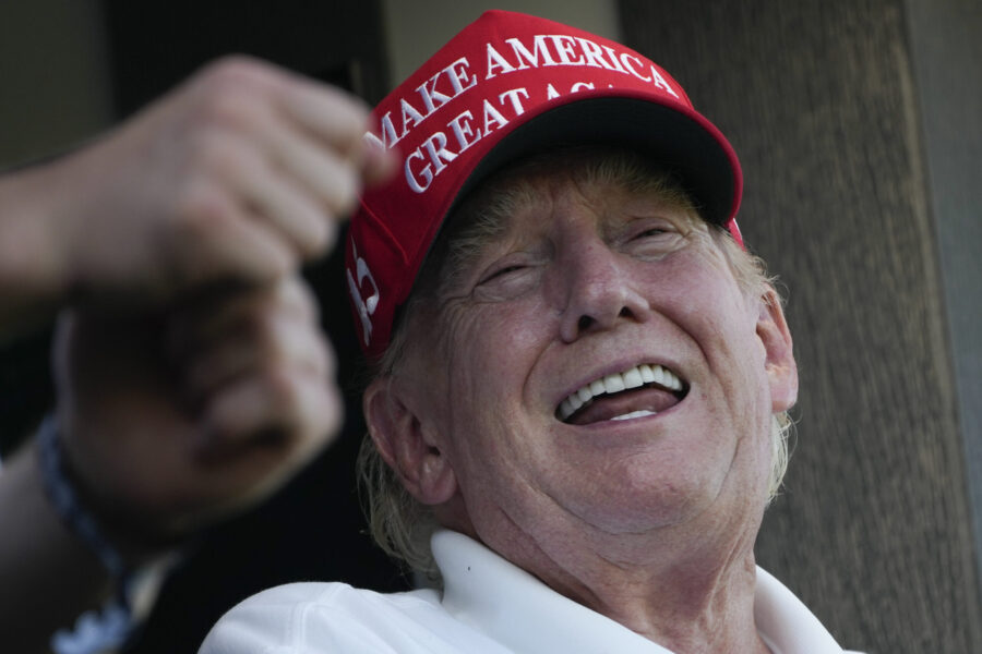 Former President Donald Trump laughs while looking over the 18th hole during the final round of the...