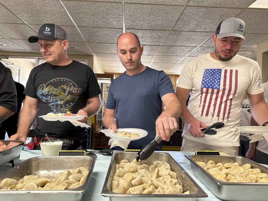 Maksym Bunchukov, Andrii Hryshchuk and Ivan Sakivskyi help themselves to perogies at a lunch hosted...
