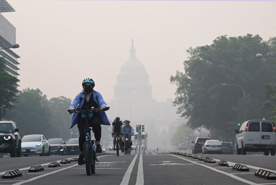 A cyclist rides under a blanket of haze partially obscuring the US Capitol in Washington, DC, on Ju...
