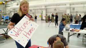 Ashley Schoolcraft helping her son, Adam, creating "welcome home" signs at Hill Air Force Base.