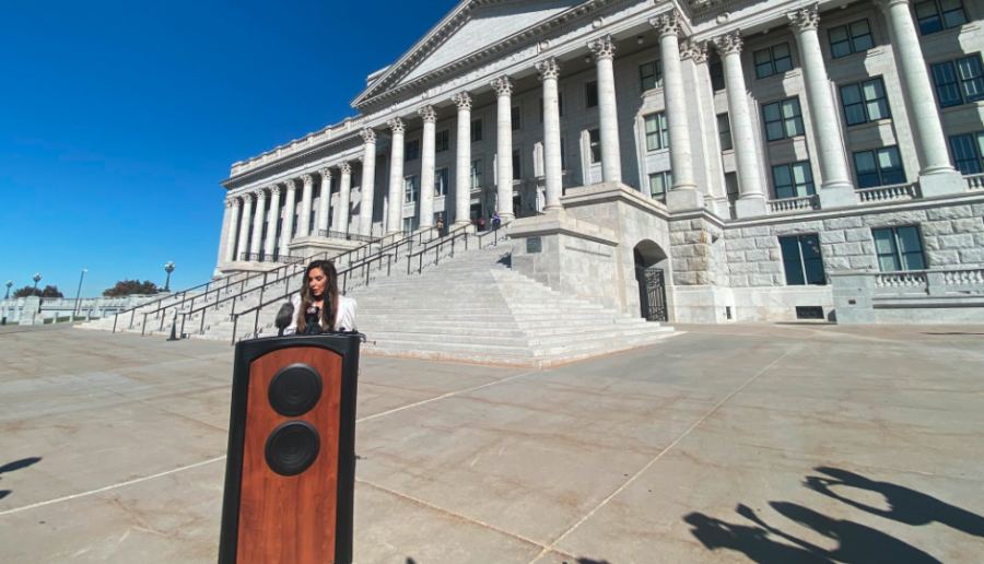 woman stands at podium at Utah State Capitol...