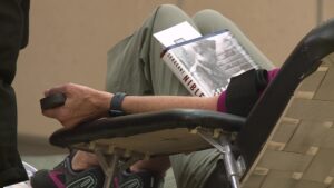 A donor reading a book while giving blood.
