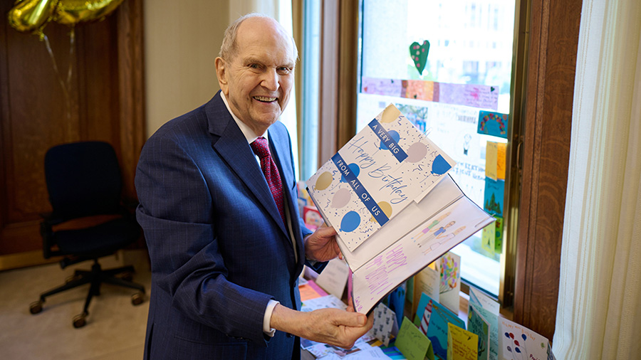 President Nelson holds a birthday card...