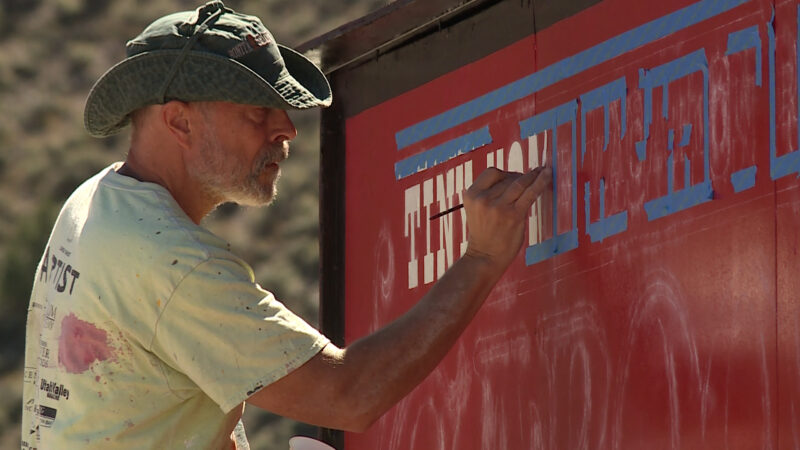 A staff worker repainting a sign in preparation for the Solar Eclipse event. (KSL TV, Mark Wetzel) 