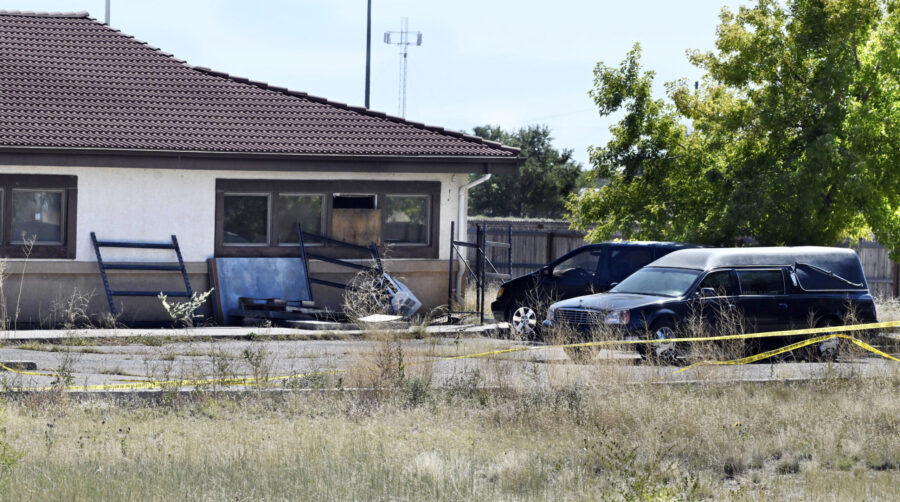 A hearse and debris can be seen at the rear of the Return to Nature Funeral Home in Penrose, Colo. ...