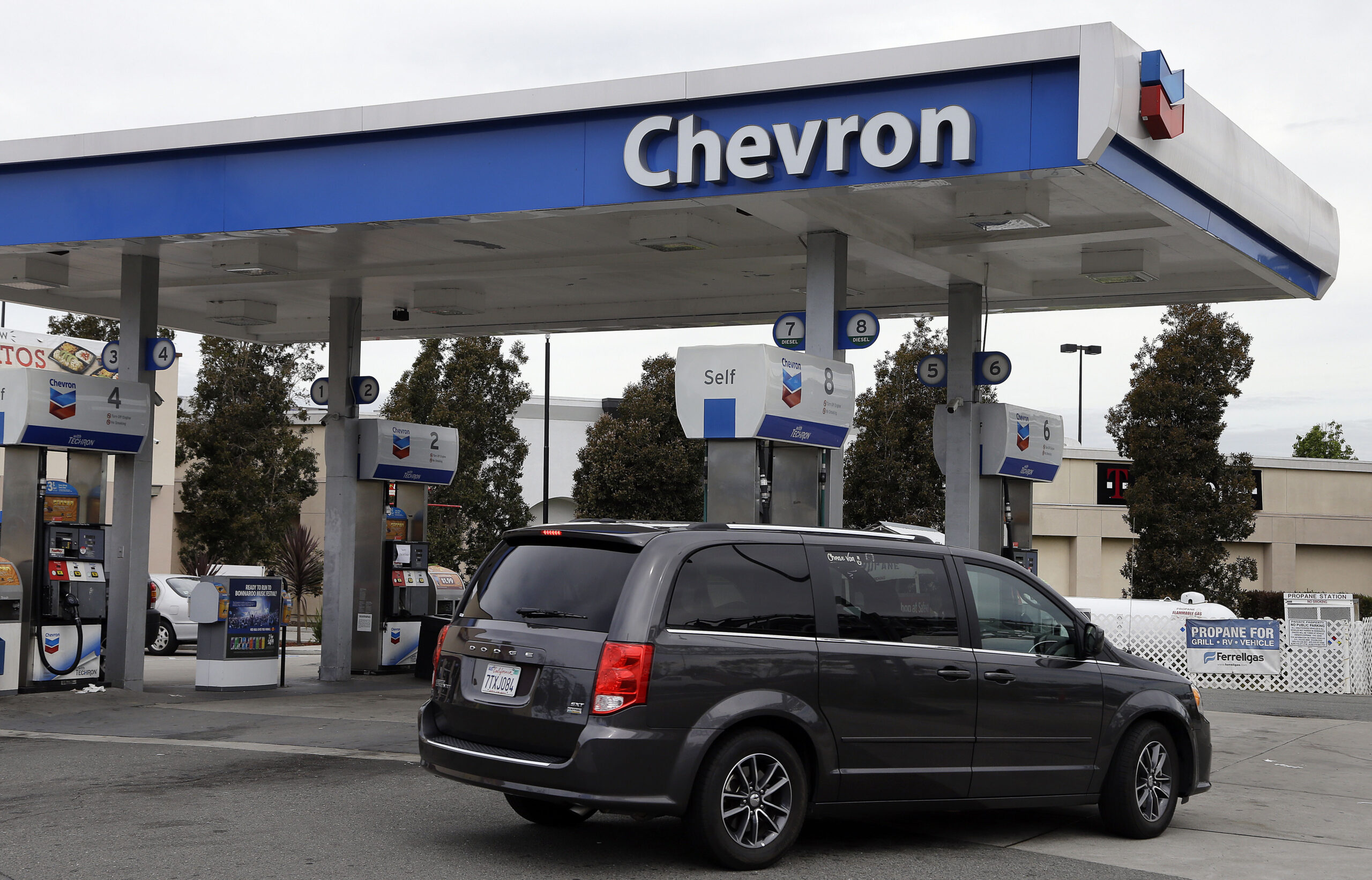FILE - A motorist drives near the pumps at a Chevron gas station in Oakland, Calif., on April 25, 2...