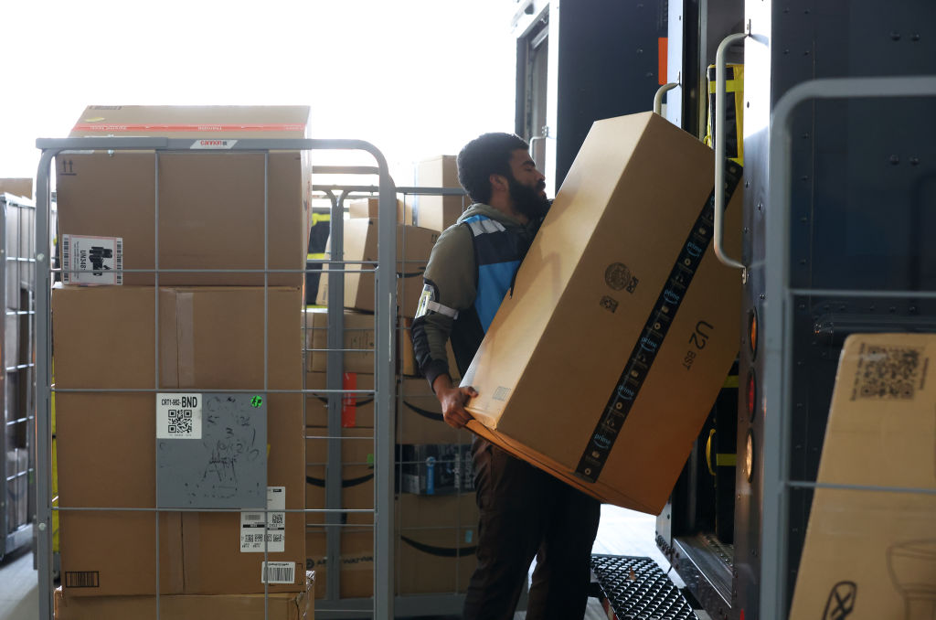 FILE: An Amazon driver loads packages into a delivery van at an Amazon delivery station on November...