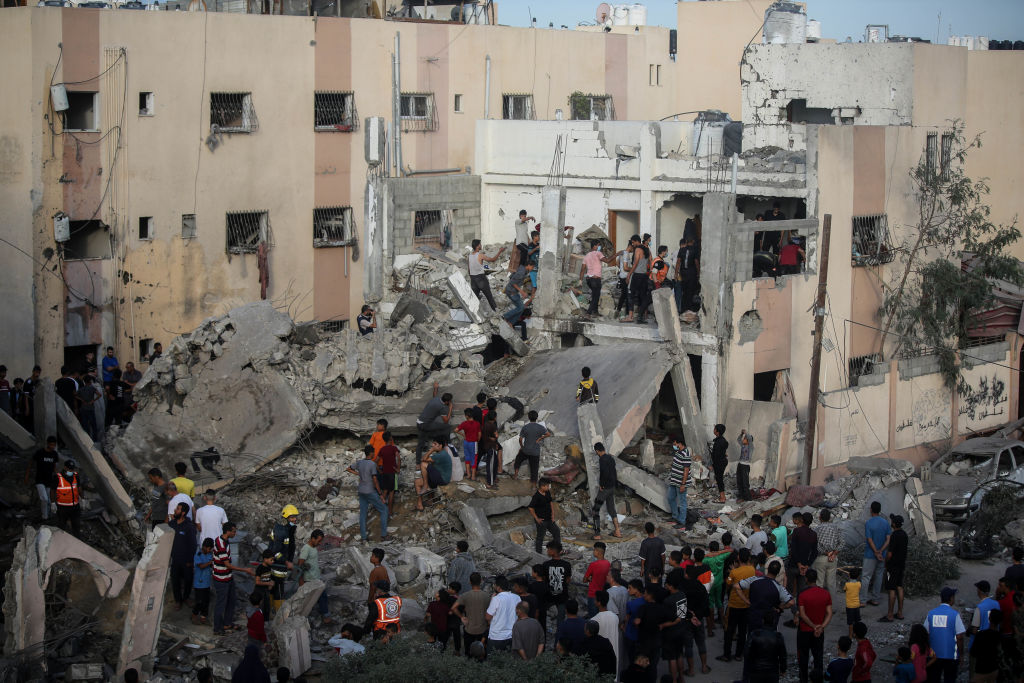Palestinian emergency services and local citizens search for victims in buildings destroyed during ...