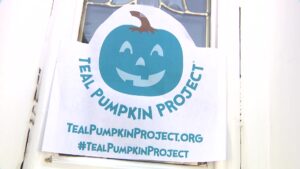 The Teal Pumpkin Project sign on a parent's house
