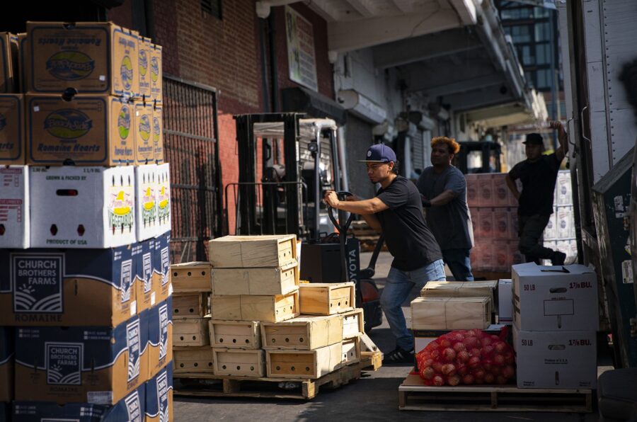 A worker prepares to wheel a pallet of food at a wholesale produce market in the Union Market distr...