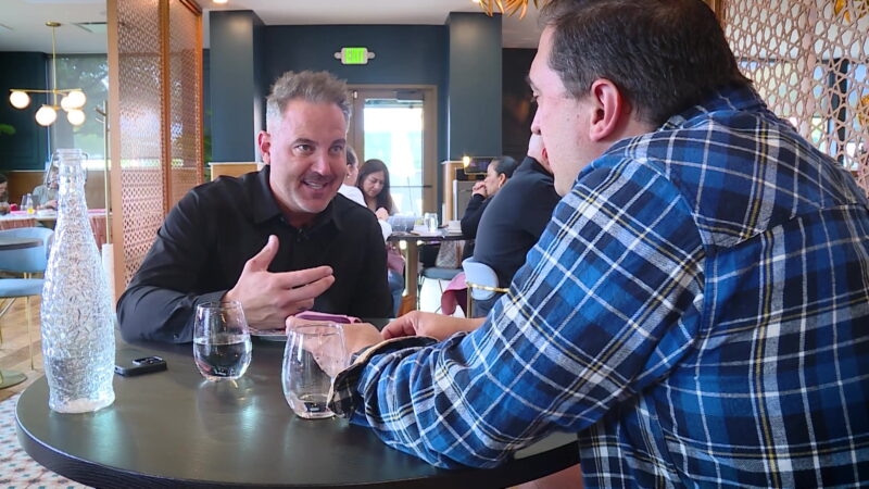 Matt Gephardt and Michael McHenry reviewing and discussing the service charge Gephardt received on his restaurant check. (KSL TV)