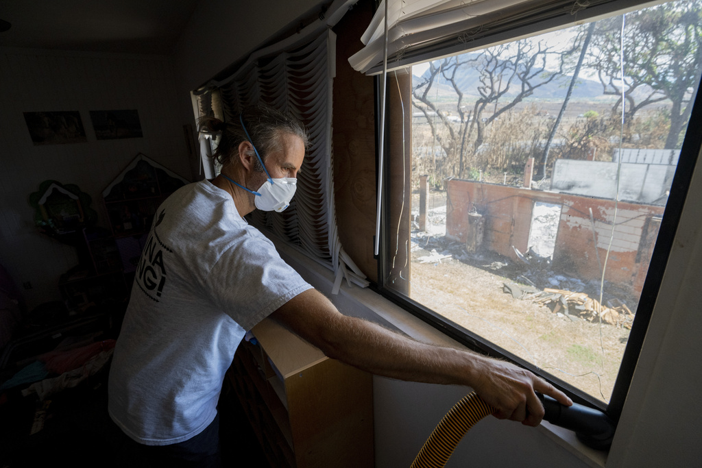 Daniel Skousen vacuums his home, damaged by August's wildfire, on Friday, Nov. 3, 2023, in Lahaina,...