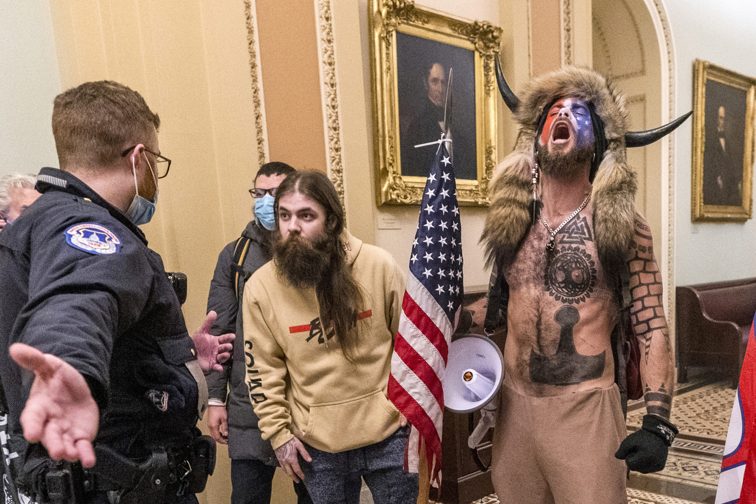 FILE - Supporters of President Donald Trump, including Jacob Chansley, right with fur hat, are conf...
