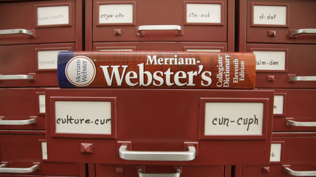 FILE - A Merriam-Webster dictionary sits atop their citation files at the dictionary publisher's of...