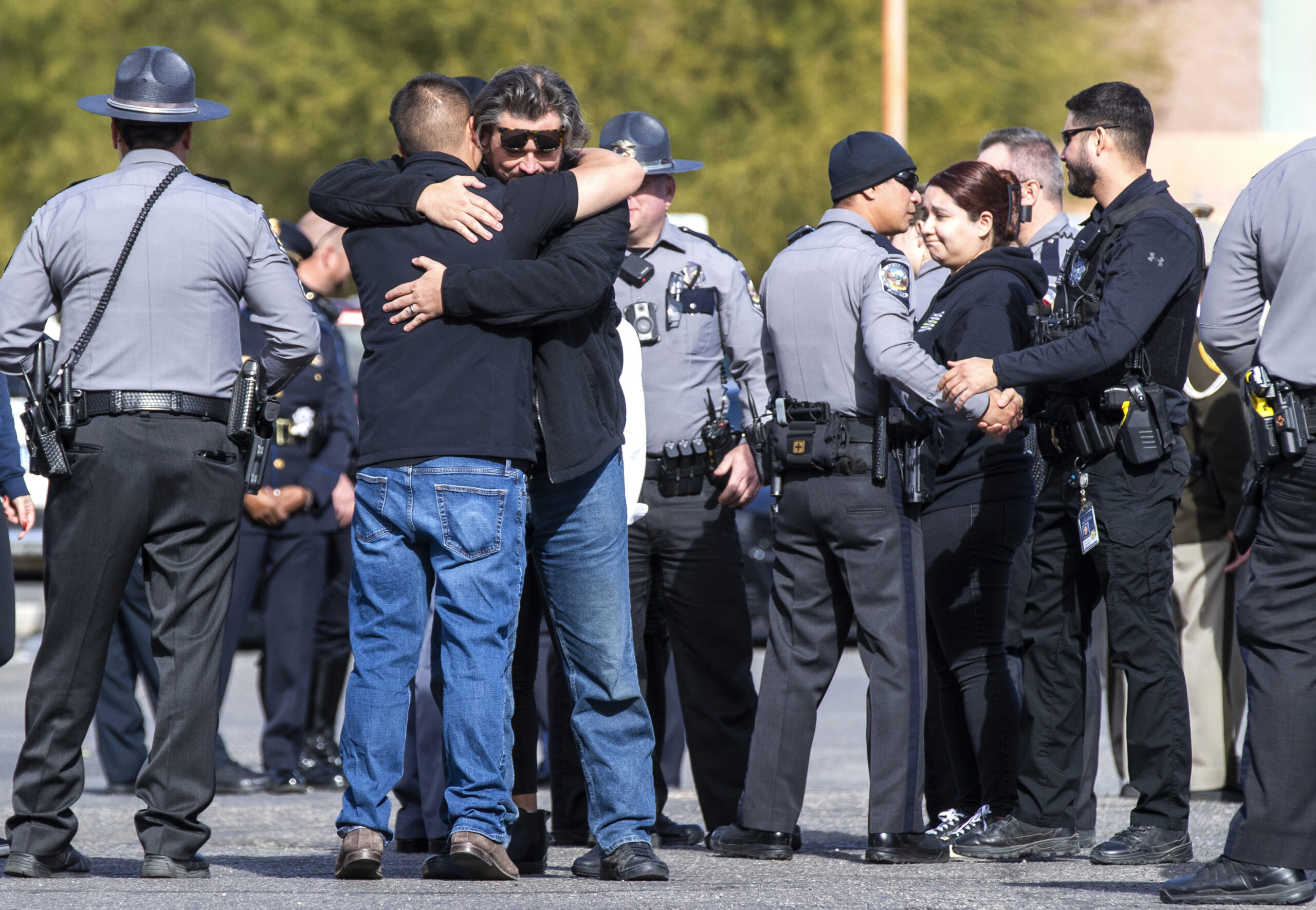 Nevada State Police and other law enforcement officers embrace in the parking lot after the body of...