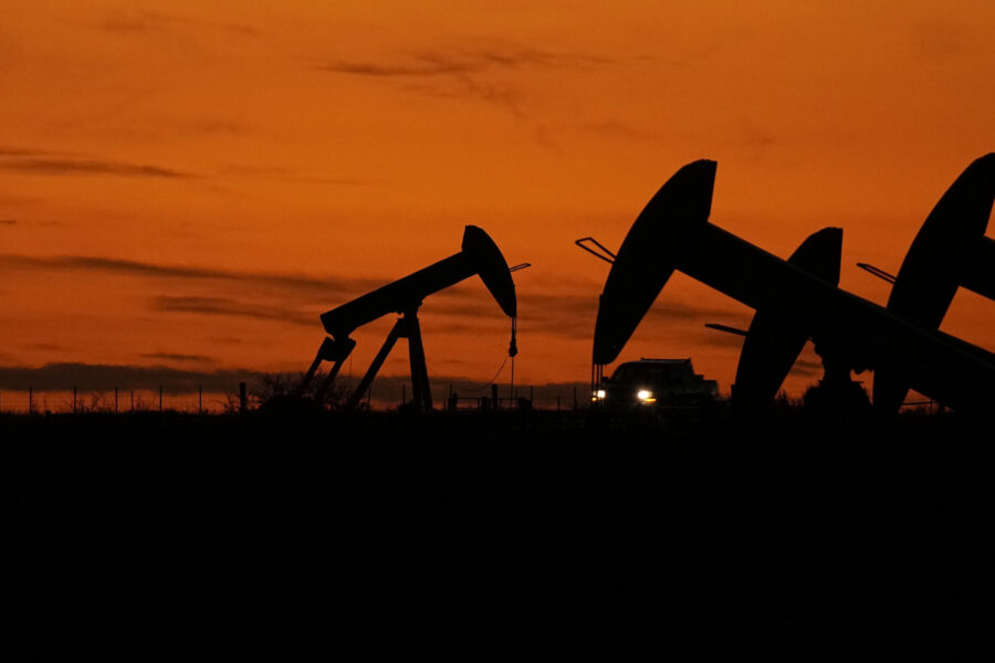 File - A truck passes oil pump jacks at dusk near Karnes City, Texas, Wednesday, Nov. 1, 2023. On W...