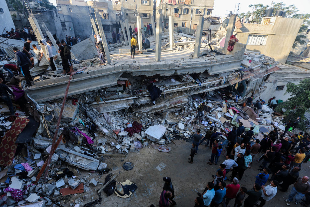 People search through buildings, destroyed during Israeli air raids in the southern Gaza Strip on N...