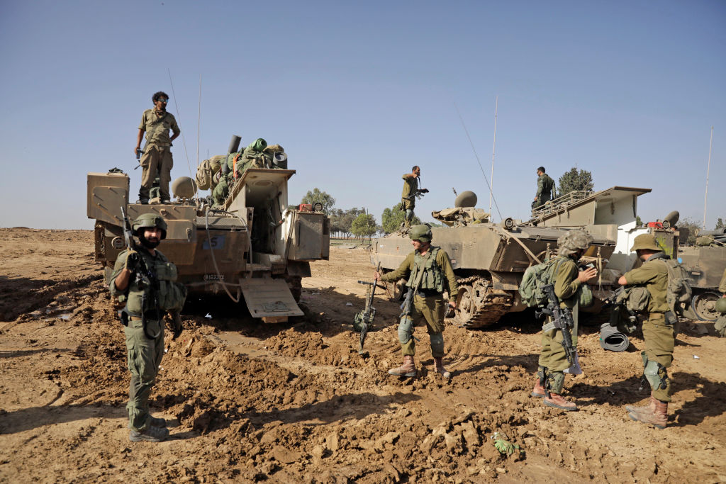 Israeli soldiers who have recently exited the Gaza Strip stand by armored personnel carriers on Nov...