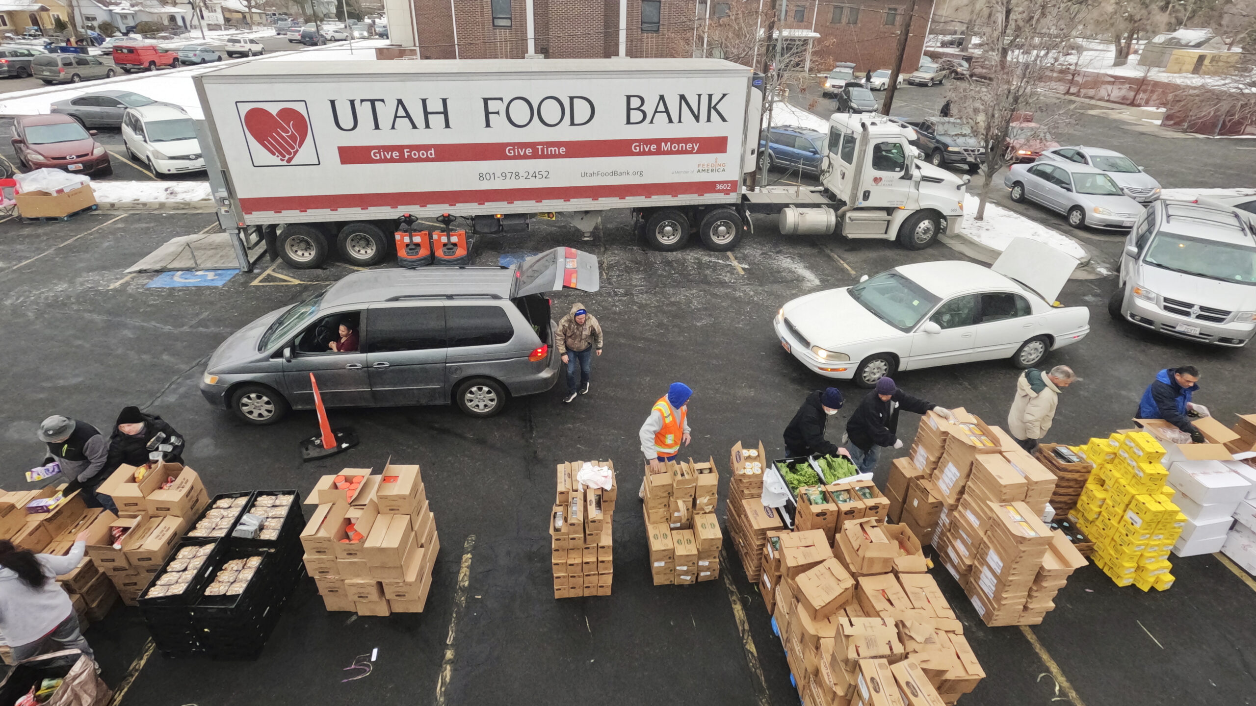 FILE - Utah Food Bank volunteers load groceries for the needy at a mobile food pantry distribution ...