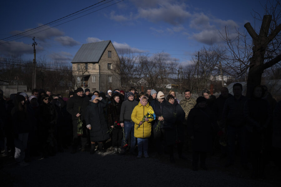FILE - People pay respect as the coffin containing the body of Serhii Havryliuk, 48, passes by duri...