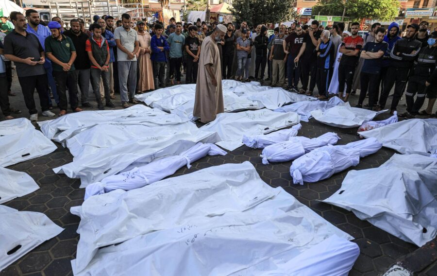 A man walks between the bodies of people killed by Israeli bombardment in Deir Balah, central Gaza,...