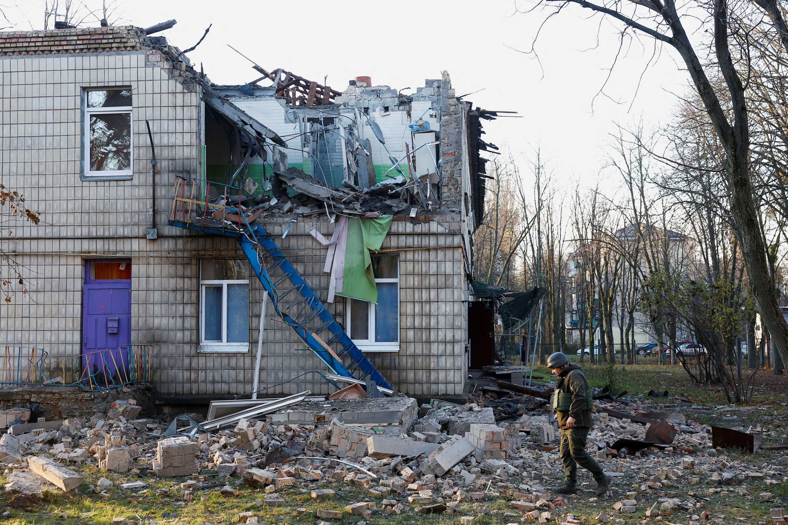 Police officers inspect the compound of a kindergarten damaged during Russian drone strikes in Kyiv...