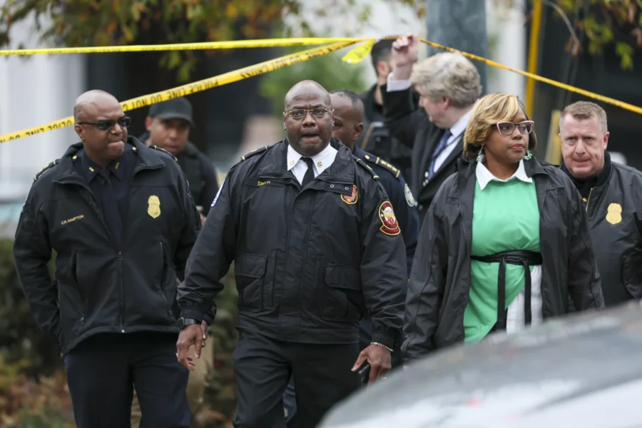 Atlanta Fire Chief, Rodrick Smith, center, and others leave the scene after a protester set themsel...