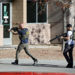 Law enforcement officers head into the University of Nevada, Las Vegas, campus after reports of an active shooter, Wednesday, Dec. 6, 2023, in Las Vegas. (Steve Marcus/Las Vegas Sun via AP)