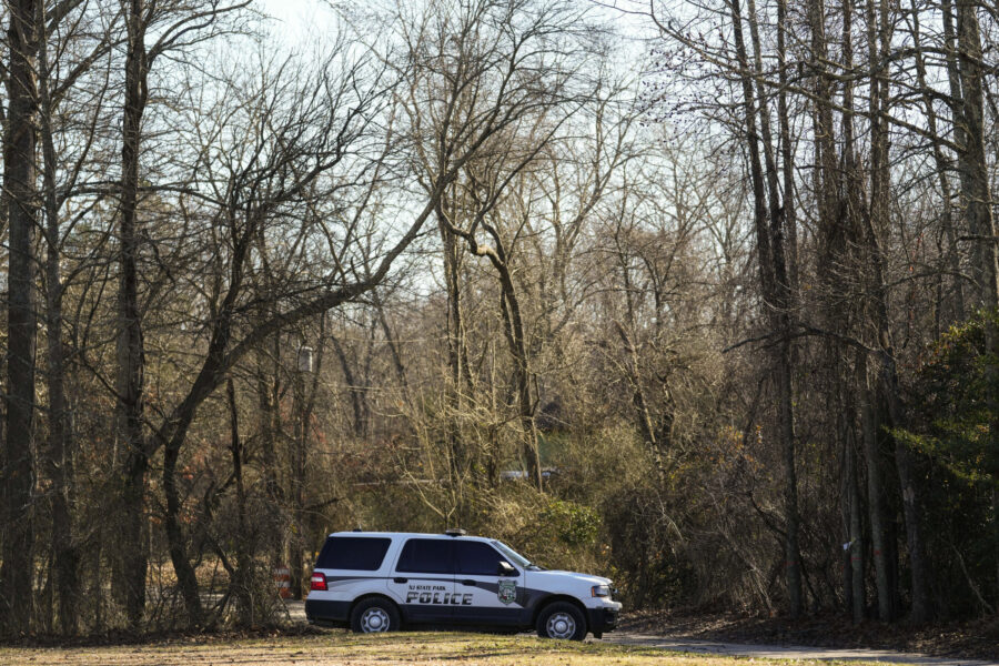 A police vehicle is parked on a road leading to the scene of a helicopter crash in Washington Towns...