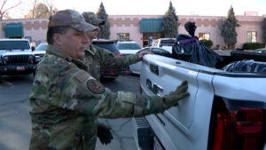 Master Sergeant Mikael Cunningham loading in gifts inside a truck.