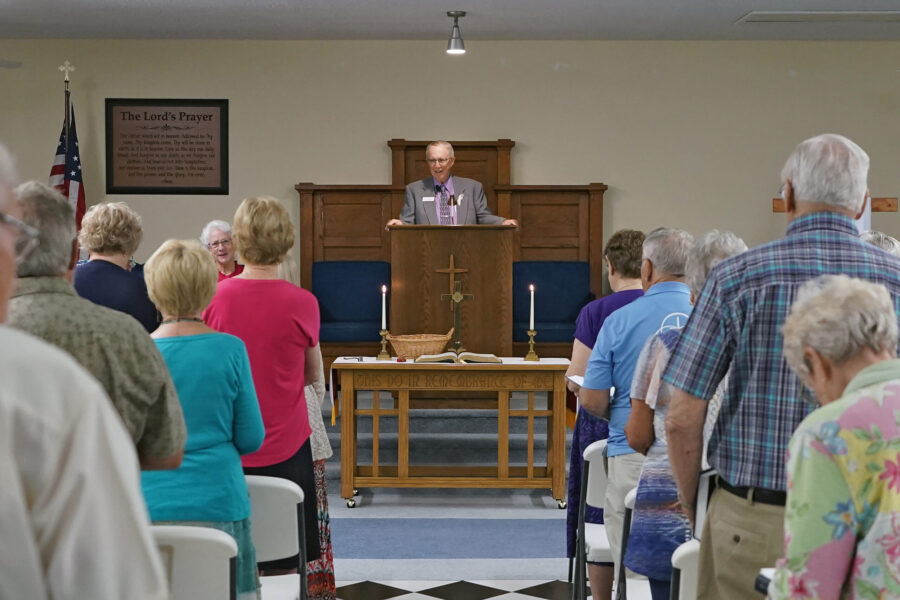 FILE - The Rev. Bill Farmer, center, speaks to members of the congregation during service at the Gr...
