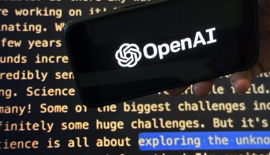 File - The OpenAI logo appears on a mobile phone in front of a screen showing part of the company w...