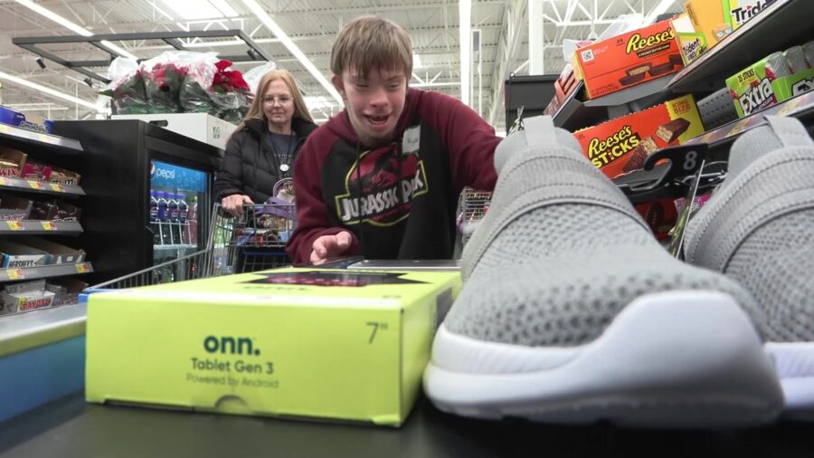 A student shops with his mentor at Wal-Mart with a $150 sum gifted to him by Christmas for Kids. (K...