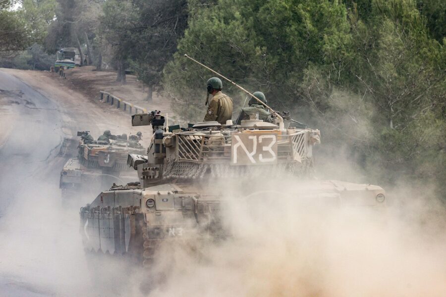 Israeli military tanks roll near the border with the Gaza Strip on December 5, amid continuing batt...