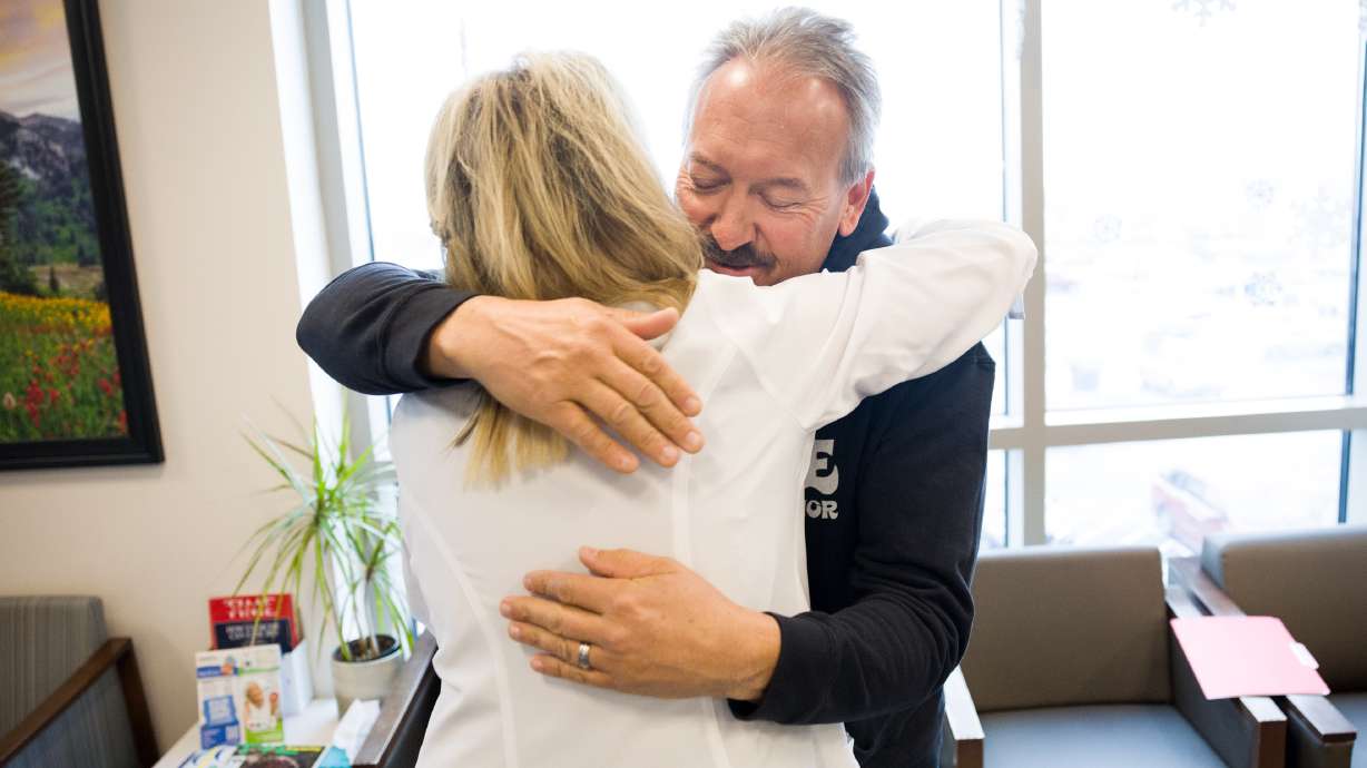 Matt Evans hugs Wendy Stapley, the living donor coordinator for Intermountain Health, after a press...