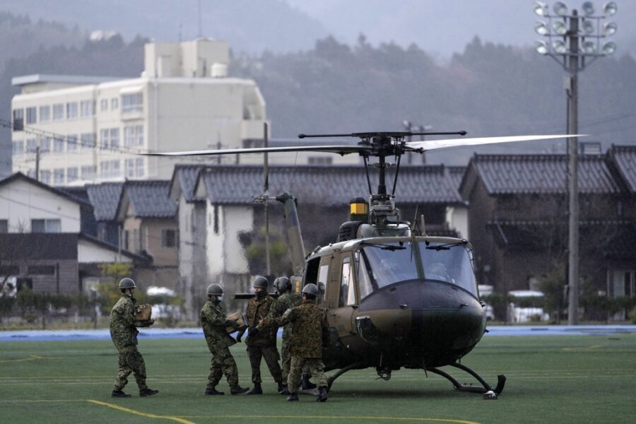 Members of the Japan Ground Self-Defense Force load relief goods into its helicopter before taking ...