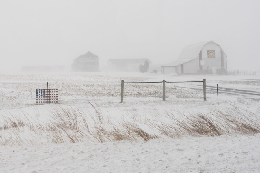 An American flag is seen fixed to a farm fence along US Highway 20 during a blizzard near Galva, Io...