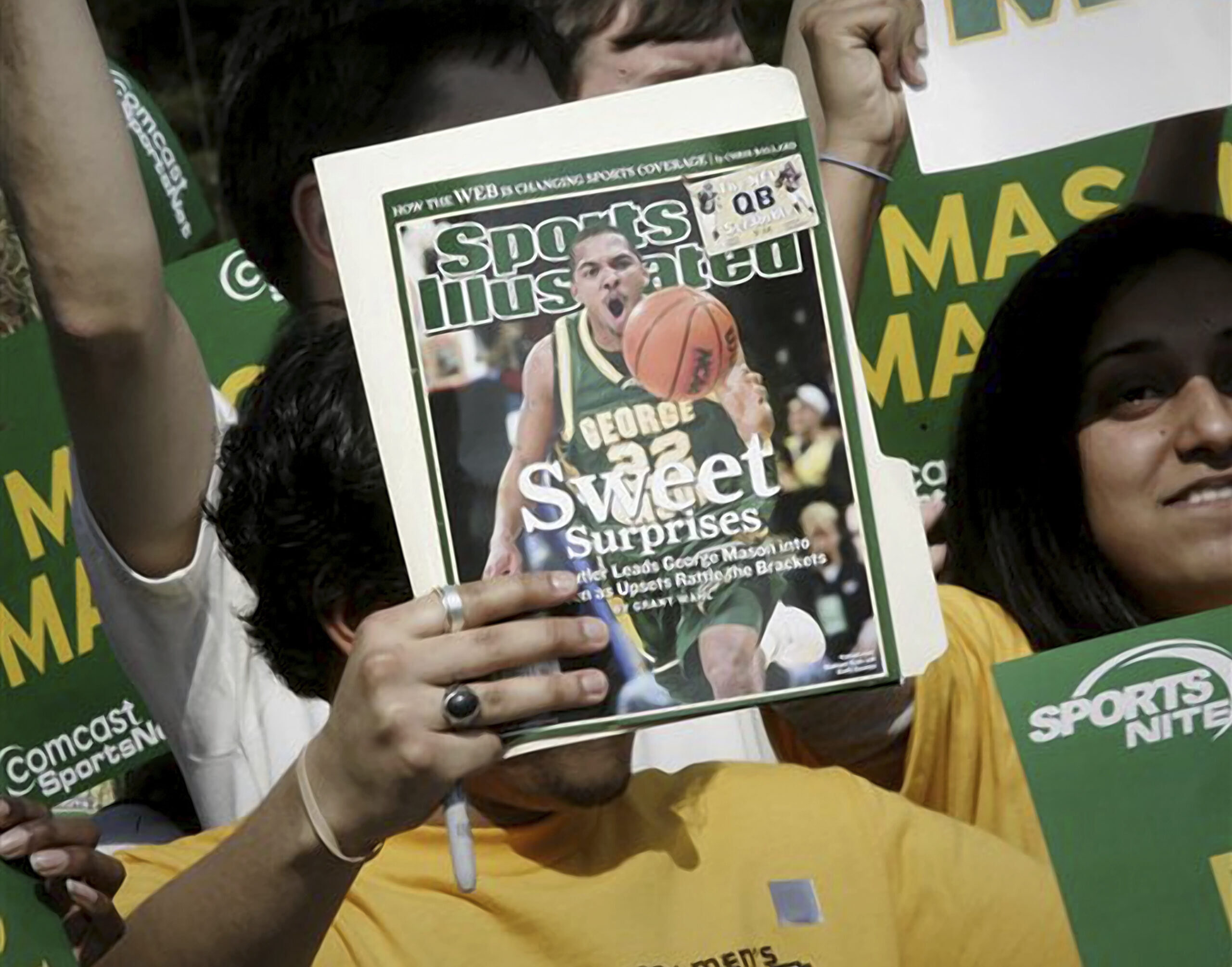 FILE - A George Mason University fan holds up the cover of Sports Illustrated magazine at a send of...