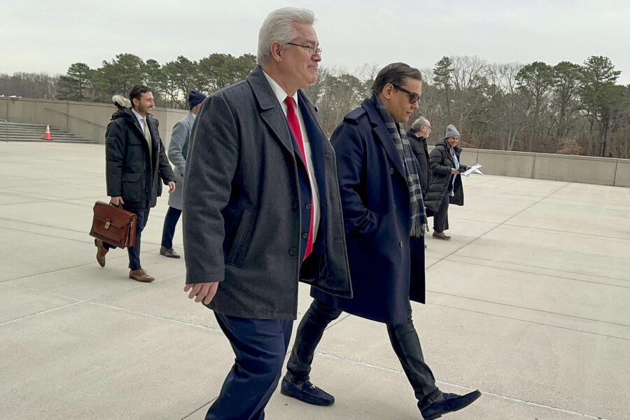 Former U.S. Rep. George Santos, right, leaves federal court with his attorney, Joseph Murray, Tuesd...