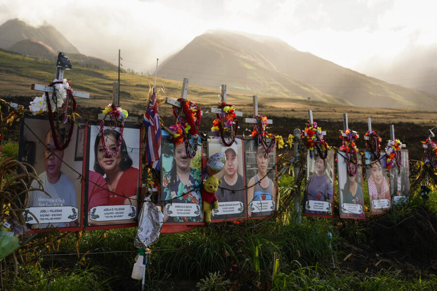 FILE - Photos of victims are displayed under white crosses at a memorial for victims of the August ...