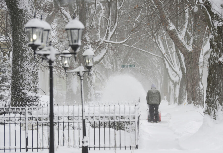 A man clears snow along a sidewalk on State Street in St. Joseph, Mich., Monday, Jan. 15, 2024. Res...