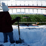 ORCHARD PARK, NEW YORK - JANUARY 15: Joanne Campbell shovels snow before the AFC Wild Card playoff game between the Buffalo Bills and Pittsburgh Steelers at Highmark Stadium on January 15, 2024 in Buffalo, New York. The Bills hired local residents to help clear snow from the stadium before today's game. A blizzard caused the game to be postponed from Sunday. (Photo by Sarah Stier/Getty Images)