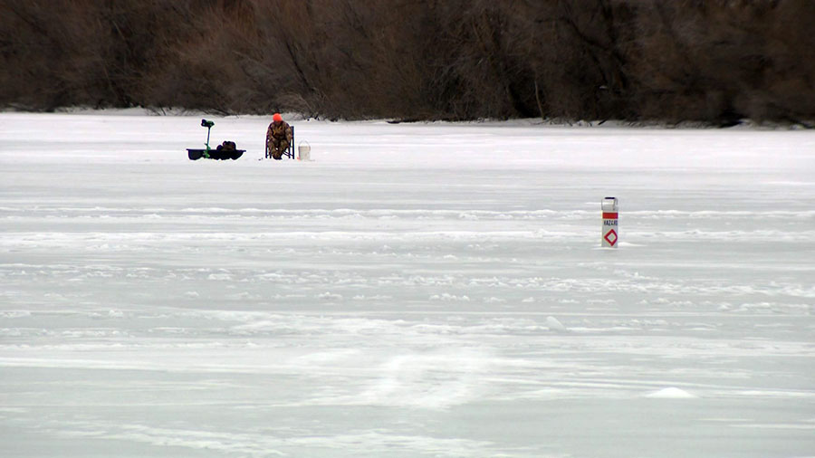 A man ice fishing on the Mantua Reservoir...