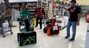 Harris and an Ace Hardware employee getting snowblowers out on the floor.