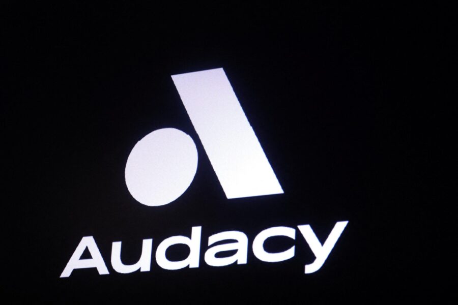 A screen displays the company logo for Audacy, Inc. on the floor of the New York Stock Exchange (NY...