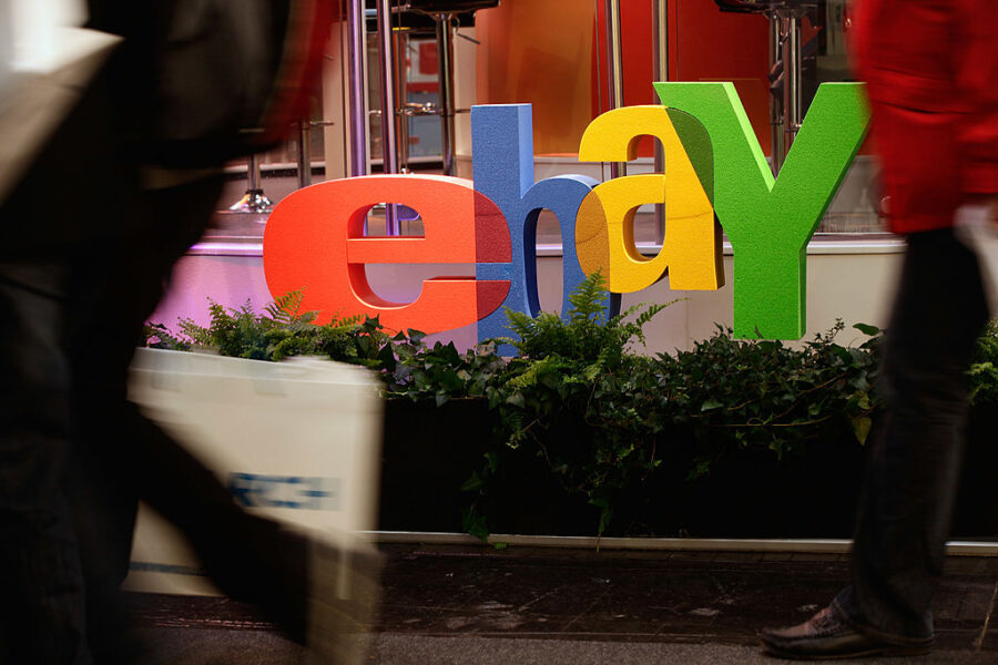 HANOVER, GERMANY - MARCH 01:  Visitors walk past the logo of online retailer eBay at the CeBIT tech...