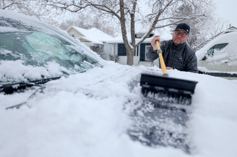 Jason Robichaud clears snow off his truck during a snowstorm in Salt Lake City on Thursday, Jan. 11...