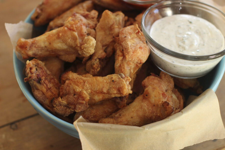 FILE - Party chicken wings with cilantro sour cream dip and honey sriracha are displayed in Concord...