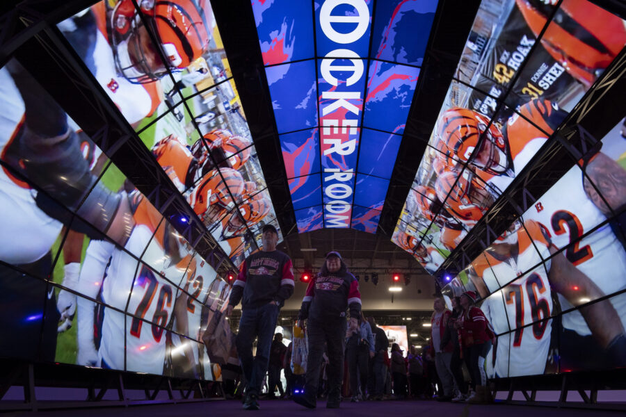 Fans walk through a tunnel of digital screens during NFL Experience ahead of Super Bowl 58, Saturda...